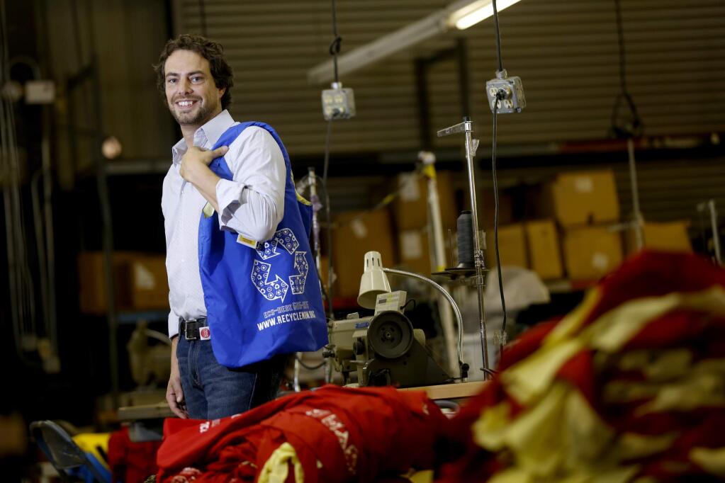 Steffen Kuehr of Bijan's Protective Equipment shows off one of the 10,000 reusable bags made by the company for the Sonoma County Waste Management Agency. Photo taken in Santa Rosa, on Wednesday, July 23, 2014. (BETH SCHLANKER/ The Press Democrat)