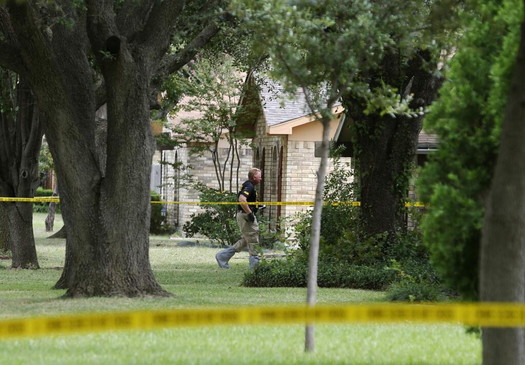 FILE - In this Sept. 12, 2017, file photo, police investigate at the scene of a shooting on West Spring Creek Parkway in Plano, Texas. Authorities have arrested a bartender who served drinks to a man who later went to his estranged wife's home and fatally shot her and seven others as they gathered to watch the Dallas Cowboys play. Lindsey Glass was arrested last week and charged with a misdemeanor violation of 'sale to certain persons.' The law prohibits the sale of alcohol to a 'habitual drunkard or an intoxicated or insane person.' Authorities say 32-year-old Hight in September 2017 already showed signs of intoxication at the Plano bar before leaving for the home of Meredith Hight and opening fire. (Vernon Bryant/The Dallas Morning News via AP, File)