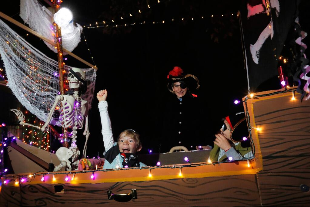 Zoe Zbinden, 8, left, and her siblings Wyatt, 12, and Jesse, 9, crew a couch decorated as a pirate ship for the lighted couch parade during Winterblast at the SOFA arts district in Santa Rosa, California, on Saturday, November 17, 2018. (Alvin Jornada / The Press Democrat)