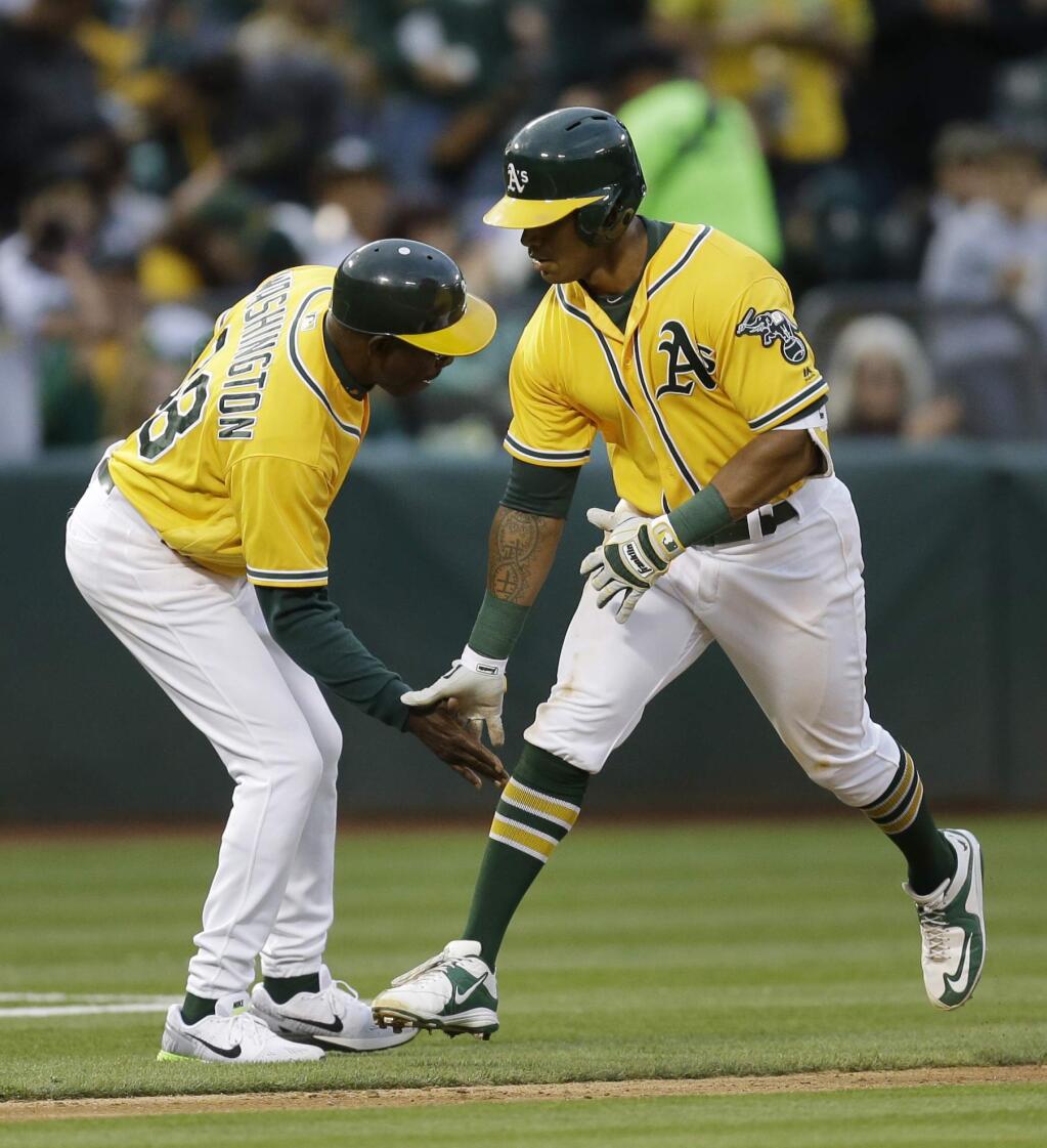 Oakland Athletics' Khris Davis, right, celebrates with third base coach Ron Washington after hitting a home run off Los Angeles Angels' Matt Shoemaker during the fourth inning of a baseball game Friday, June 17, 2016, in Oakland, Calif. (AP Photo/Ben Margot)