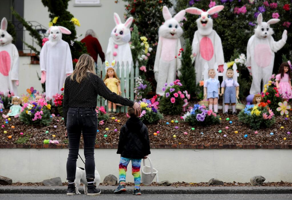 Melissa Abercrombie and her son Orion, 4, check out an Easter-themed display of bunny costumes, large vintage dolls, artificial flowers and plastic eggs in the front yard of 6 El Rose Drive in Petaluma, California on Sunday, April 12, 2020. (BETH SCHLANKER/ The Press Democrat)