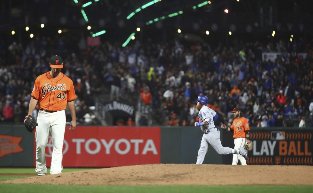San Francisco Giants' Madison Bumgarner, left, waits for Los Angeles Dodgers' Justin Turner, right, to run the bases after hitting a two-run home run during the fifth inning of a baseball game Friday, Sept. 28, 2018, in San Francisco. (AP Photo/Ben Margot)