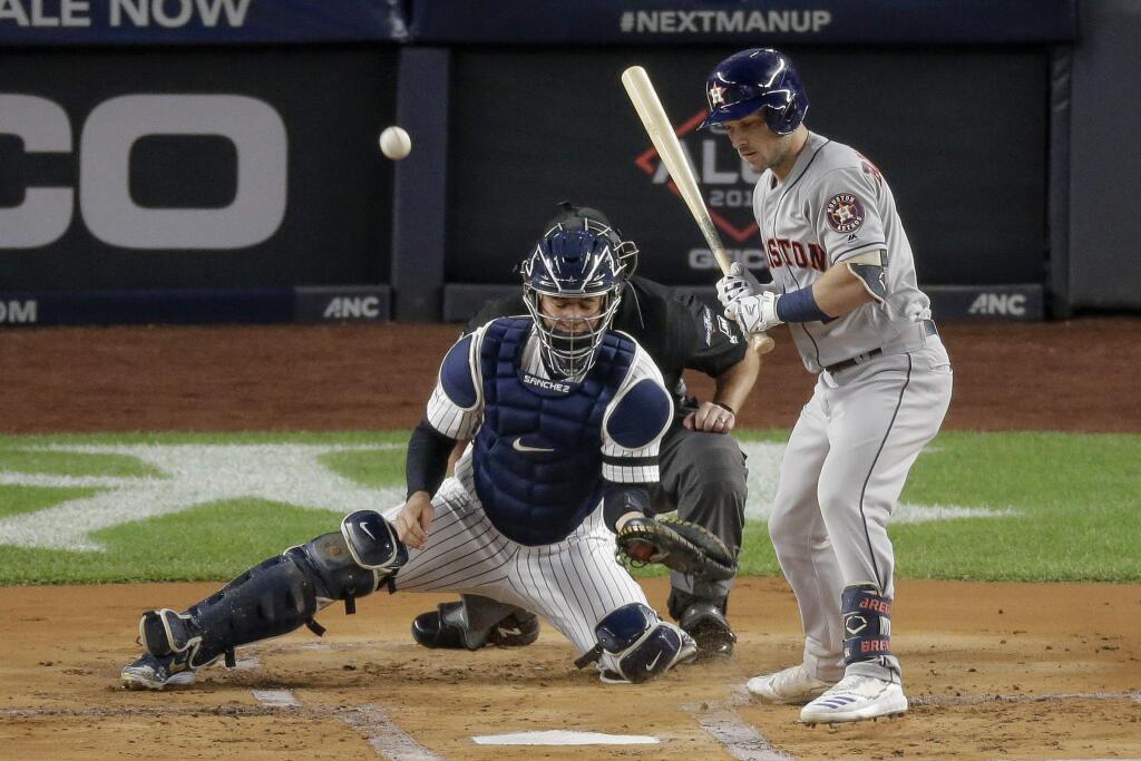 A wild pitch bounces away from New York Yankees catcher Gary Sanchez as Houston Astros' Michael Brantley looks on during the first inning of Game 5 of baseball's American League Championship Series, Friday, Oct. 18, 2019, in New York. George Springer scored on the play. (AP Photo/Seth Wenig)