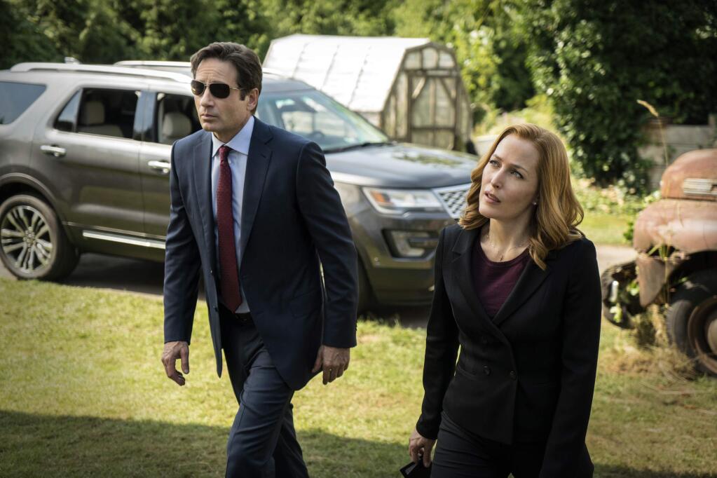 This photo provided by FOX shows, David Duchovny, left, as Fox Mulder and Gillian Anderson as Dana Scully in an episode of 'The X-Files.' (Ed Araquel/FOX via AP)