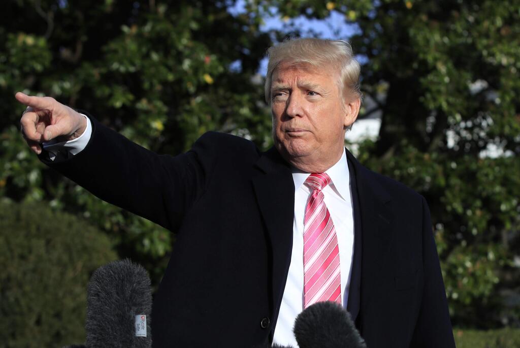 President Donald Trump points to reporters after speaking at the White House, Tuesday, Nov. 21, 2017, in Washington, as he and his family were leaving for a Thanksgiving trip to his Mar-a-Lago estate in Palm Beach, Fla. (AP Photo/Manuel Balce Ceneta)