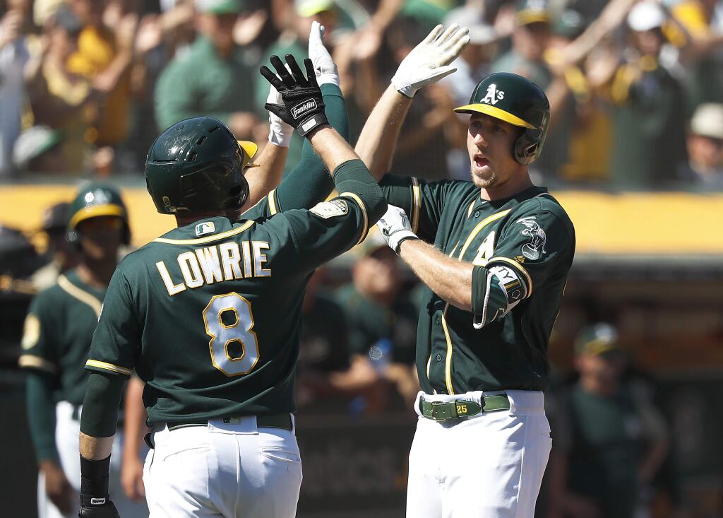 The Oakland Athletics' Stephen Piscotty, right, is congratulated by teammate Jed Lowrie after hitting a three-run home run during the third inning in Oakland, Thursday, Sept. 20, 2018. (AP Photo/Tony Avelar)