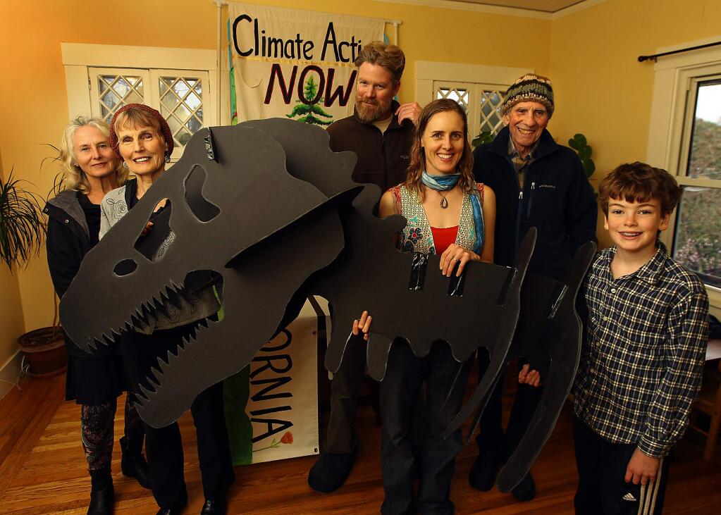 Sebastopol residents, left to right, Anna Jacopetti, Janet Powers Wolfe, Wyndham and Sunny Galbraith, Roland Jacopetti and Leo Galbraith, 10, with the dinosaur head they will take to the Oakland anti-fracking rally on Sunday. (Photo by John Burgess/The Press Democrat)