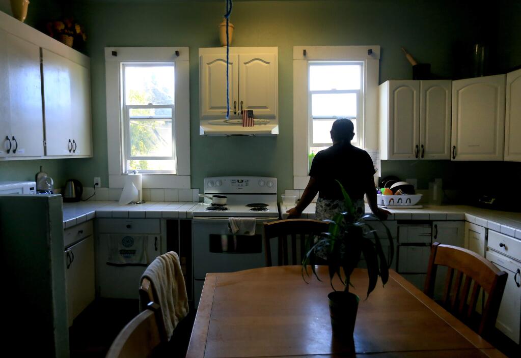 A resident of a YWCA domestic violence safe house in Santa Rosa stands in the kitchen of the facility on Tuesday, June 2, 2015. (KENT PORTER/ PD)