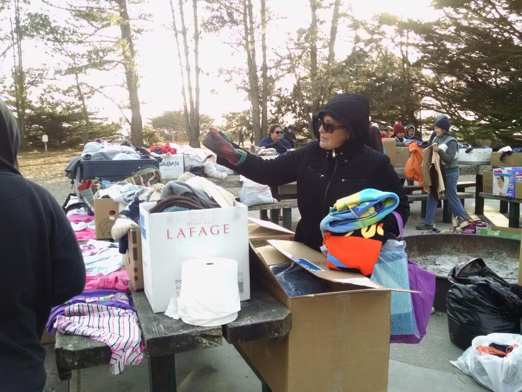 Evacuee Mirian Martinez of Larkfield views donations brought to Doran Regional Park by Bodega Bay residents. (MARY FRICKER)
