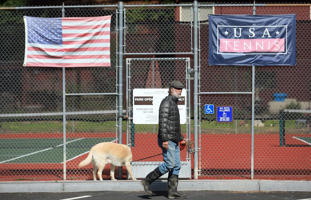Ron Amiot takes his dog for a morning walk along Drake Road in Guerneville, Friday, March 27, 2020. Amiot is one of a growing number of residents in the river and coast areas that are worried about the vacation rentals and the crowds they bring in during the pandemic. (Kent Porter / The Press Democrat) 2020