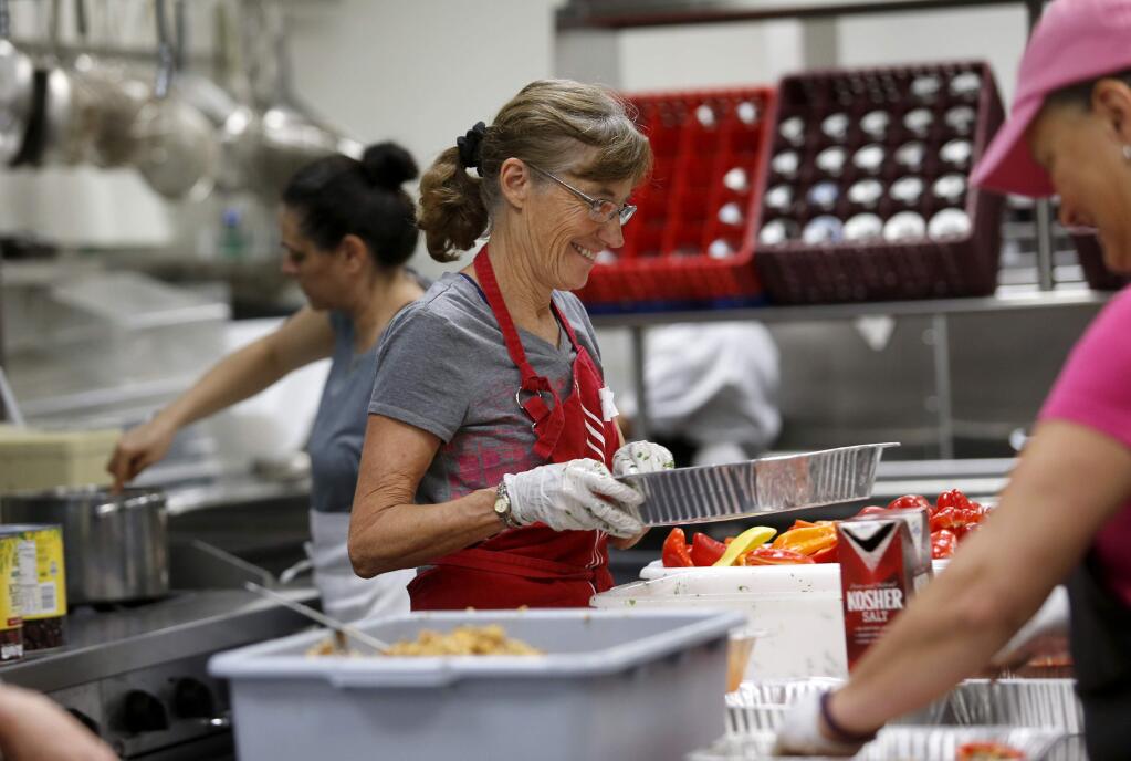 Deborah Cutler, a volunteer with Sonoma Family Meal, puts together stuffed bell peppers to be cooked in the kitchen of the Vintners Inn in Fulton, on Tuesday, October 24, 2017. (BETH SCHLANKER/ The Press Democrat)