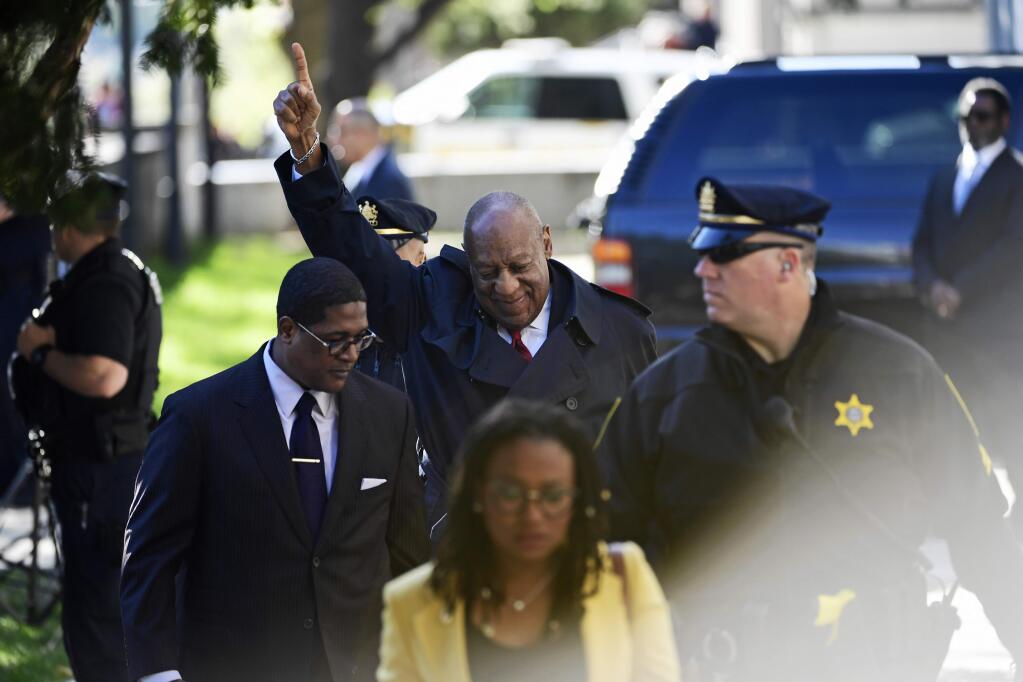 Bill Cosby, center, reacts after spokesperson Andrew Wyatt, left, addressed the media for Cosby's sexual assault trial at the Montgomery County Courthouse, Thursday, April 26, 2018, in Norristown, Pa. (AP Photo/Corey Perrine)