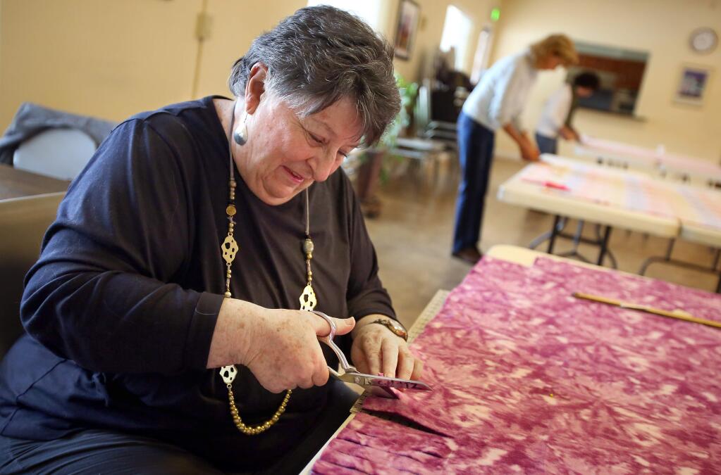 PHOTO: 2 BY CHRISTOPHER CHUNG/ THE PRESS DEMOCRAT -Joan Schatz makes a blanket with the Sonoma Blanket Brigade on Friday. For the past seven years, volunteers have gotten together once a month to make blankets for people in need.
