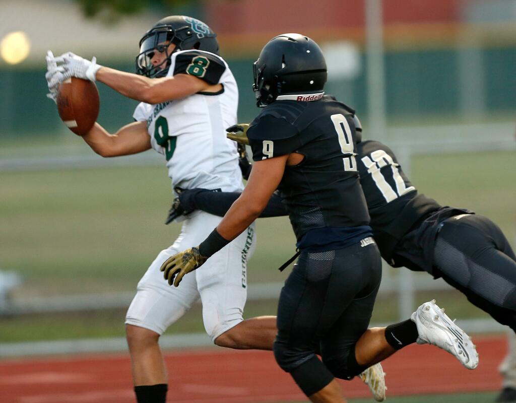 Casa Grande's Dominic McHale, left, catches a touchdown pass while guarded by Windsor's Chris Torres, center, and Christian Sanchez during the first half between Casa Grande and Windsor high schools in Windsor on Friday, Aug. 17, 2018. (Alvin Jornada / The Press Democrat)