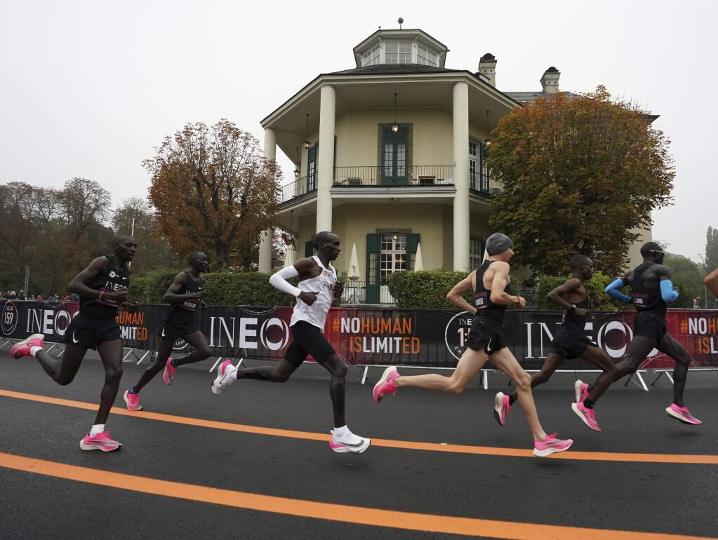 In this photo made available by The INEOS 1:59 Challenge on Saturday, Oct. 12, 2019, Eliud Kipchoge, white vest, runs past the Lusthaus with his pacemaking team in Vienna, Austria. Saturday, Oct. 12, 2019, during his attempt to run a sub two-hour marathon.(Andrew Baker /The INEOS 1:59 Challenge via AP)