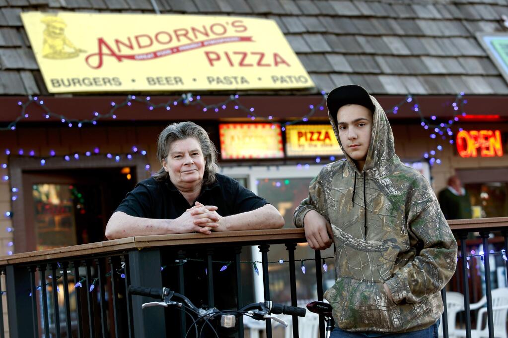 Suzy Kuhr, owner of Adorno's Pizza, left, and her employee Tristan Sharkey, 13, in Guerneville, California on Tuesday, December 29, 2015. Kuhr and Sharkey routinely check areas around Kuhr's business to make sure the building is not endangered by campfires set by homeless people. (Alvin Jornada / The Press Democrat)