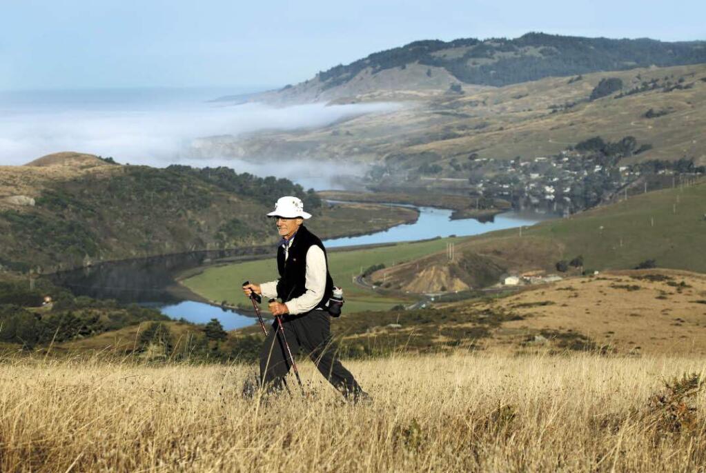 Larry Maniscalo, one of the leaders of the Oakmont Hiking Club, hikes up to Red Hill from Shell Beach with the mouth of the Russian River as a backdrop. (John Burgess / Press Democrat)