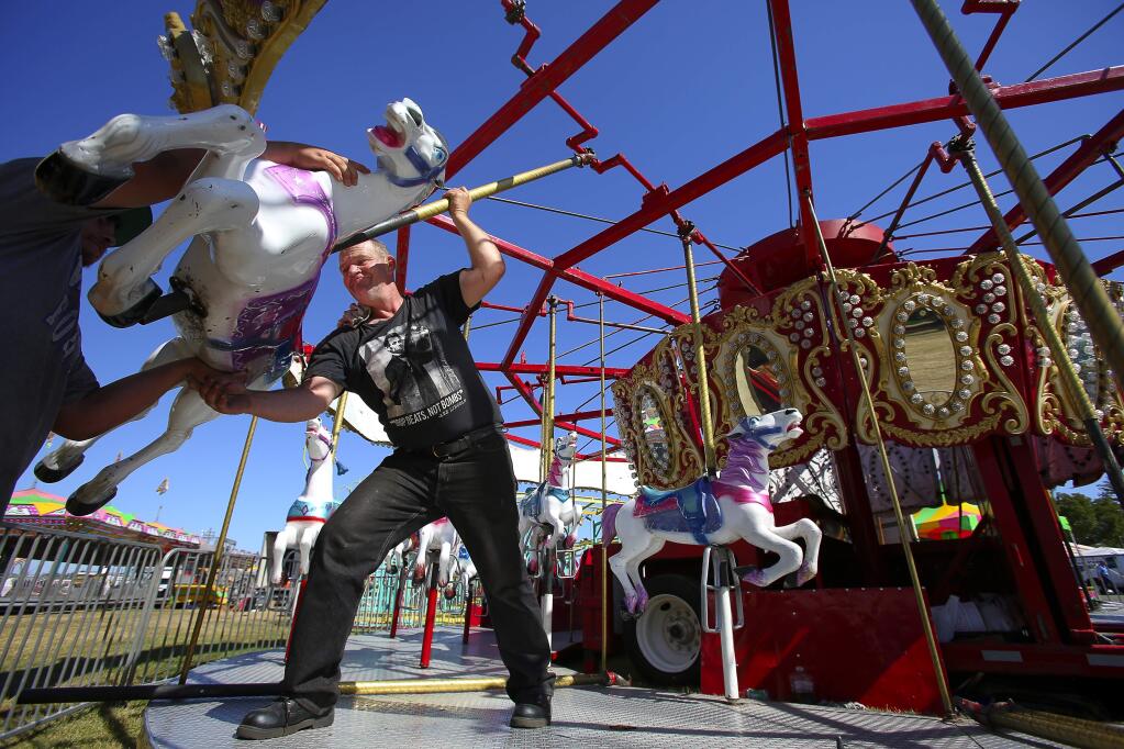 Robert Hase, right, and Jose Melendez put together the Seville carousel at the Sonoma-Marin Fair, in Petaluma, on Tuesday, June 23, 2015. (Christopher Chung/ The Press Democrat)
