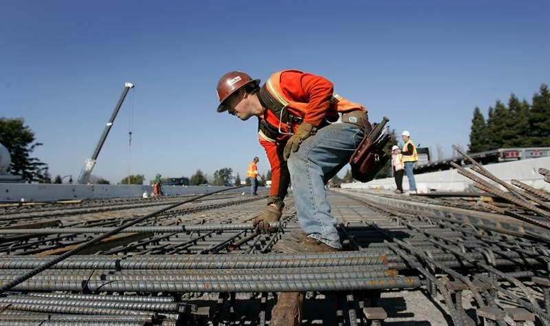 Steel worker Daniel Alvarez moves re-bar on a new Highway 101 bridge over Fourth Street in Santa Rosa, Wednesday Jan. 24, 2007, as work continues on the widening of the freeway through Santa Rosa. (Kent Porter / The Press Democrat) 2007