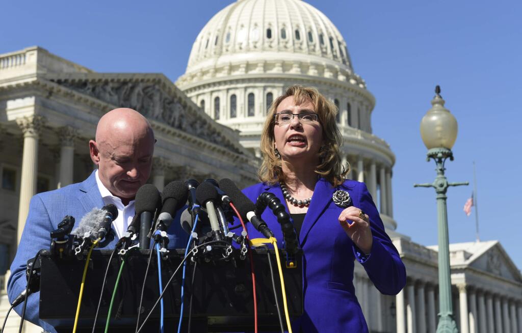 Former Rep. Gabrielle Giffords, D-Ariz., right, standing with her husband Mark Kelly, left, speaks on Capitol Hill in Washington, Monday, Oct. 2, 2017, about the mass shooting in Las Vegas. Giffords, was a congresswoman when she was shot in an assassination attempt in 2011. (AP Photo/Susan Walsh)