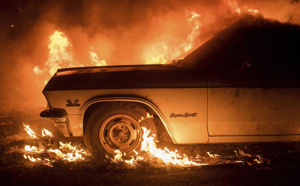 Flames from a wildfire consume a car near Oroville, Calif., on Saturday, July 8, 2017. Evening winds drove the fire through several neighborhoods leveling homes in its path. (AP Photo/Noah Berger)