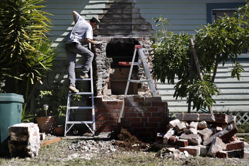 Dave Holstein tries to clean up the debris from his fallen chimney from the earthquake in Napa on Wednesday, Aug. 27, 2014. (BETH SCHLANKER/ PD)