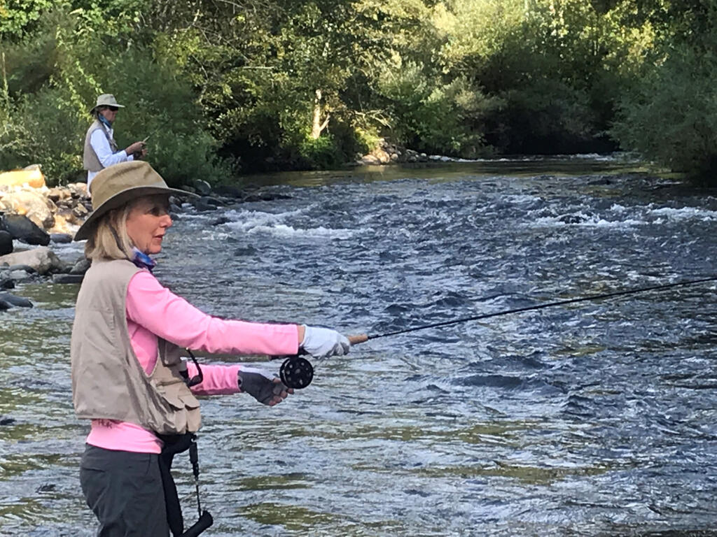 JEANNE MONTAGUE casts a fly toward a waiting rainbow trout on the upper Sacramento River while her husband, Chad Overway, fishes just upstream. (Submitted)
