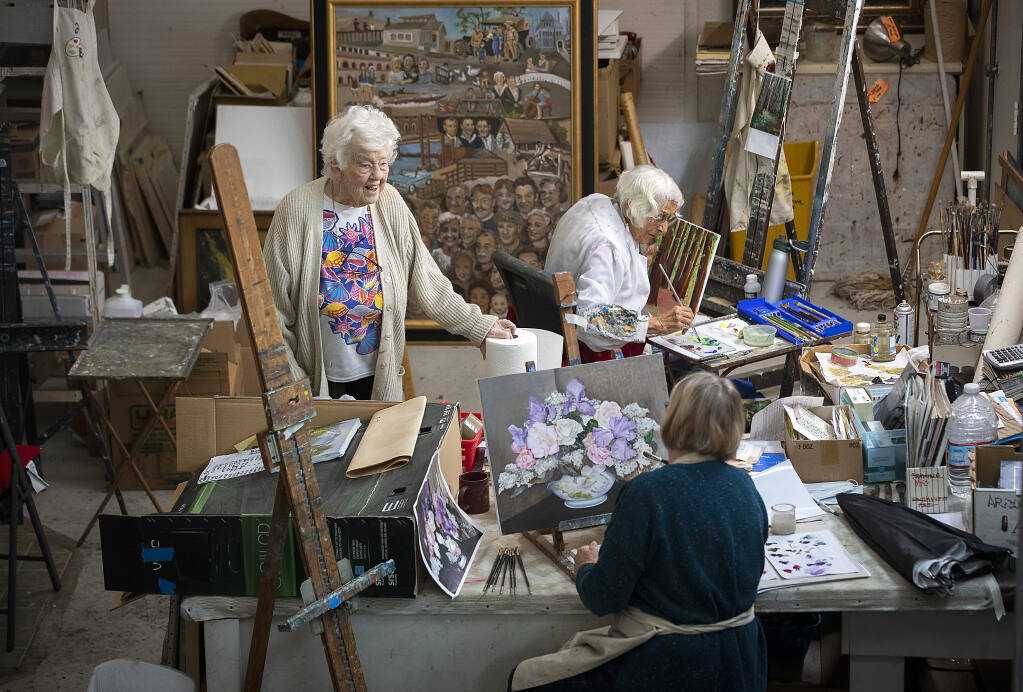 Ninety-nine-year-old Adele Pruitt, left, teaches painting in her Ukiah studio to students Jeanette Carson, bottom, and Jeanette Bylund, 93, on Wednesday, December 15, 2021.  (Photo by John Burgess/The Press Democrat)