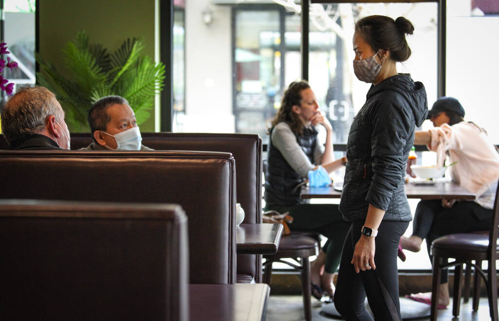 Song Nguyen, co-owner of Pho Sonoma in Petaluma chats with guests, Dan Noone and Danny Mai who ate lunch in one of the booths in Petaluma on Sunday, March 14, 2021. (Crissy Pascual / Argus-Courier)