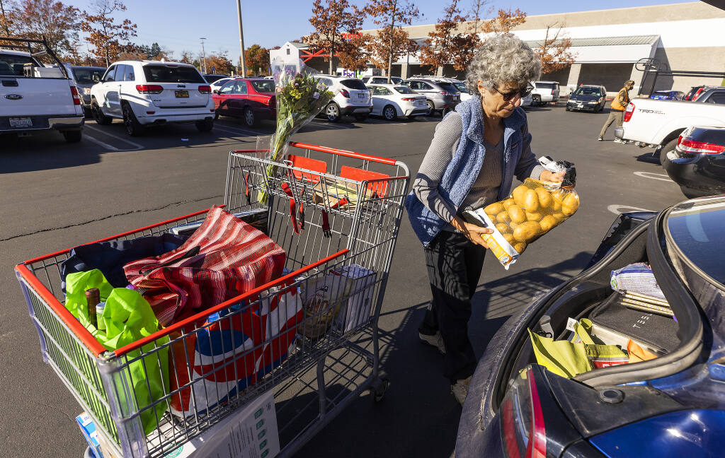 Denise Meier, of Sebastopol, loads her groceries for Thanksgiving into her car at Costco in Santa Rosa on Monday, Nov. 22, 2021. Shoppers are seeing a 5% increase in food prices this year. (John Burgess/The Press Democrat)