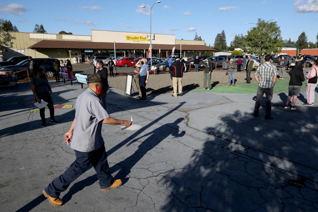 People wait in line for free COVID-19 testing outside the Roseland Community Library in Santa Rosa, California on Thursday, November 19, 2020. (Beth Schlanker/ The Press Democrat)