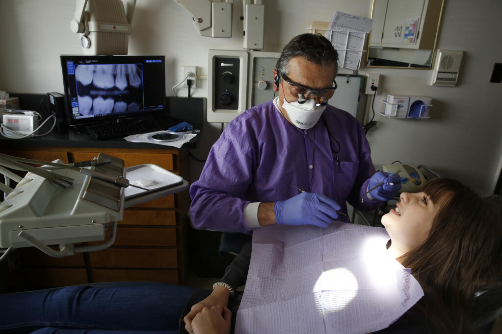 Dr. Anthony Fernandez conducts a dental exam on Addison Knobel, 13, at his office in Santa Rosa, Calif., on Wednesday, January 13, 2021. (BETH SCHLANKER/ The Press Democrat)