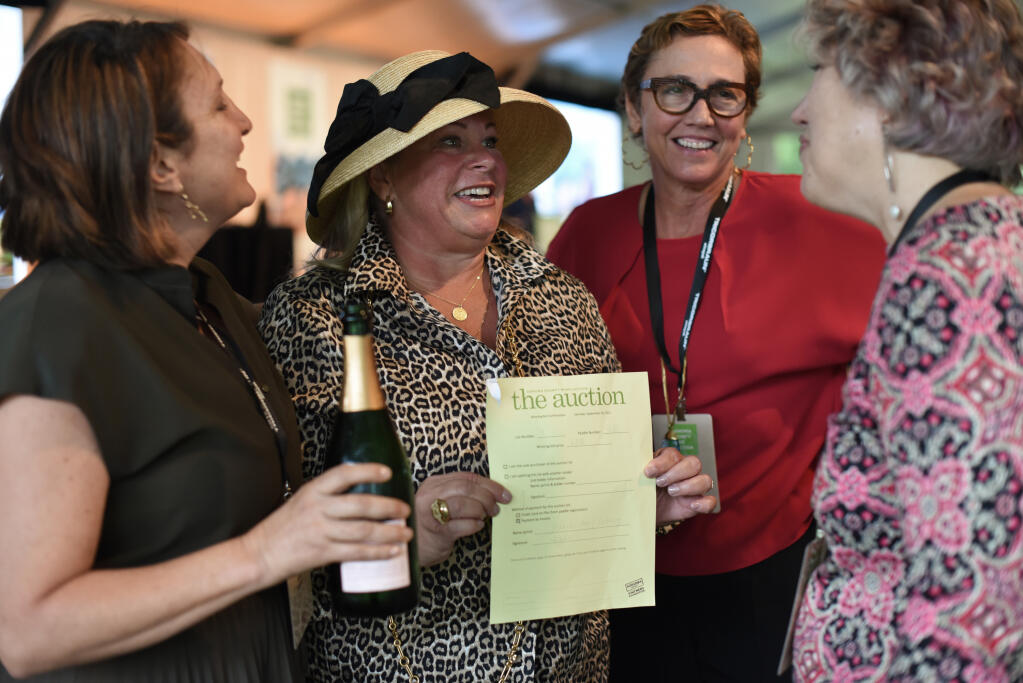 Jennifer Lickteig, second from left, after her winning bid for auction item #11, a night out with 12 leading ladies in the Sonoma County wine industry, celebrates with, from left, Ana Keller, Leigh Ann Albers and Bettina Sichel during the Sonoma County Wine Auction at La Crema Estate at Saralee’s Vineyard in Windsor on Saturday, Sept. 18, 2021.  (Erik Castro / for The Press Democrat)