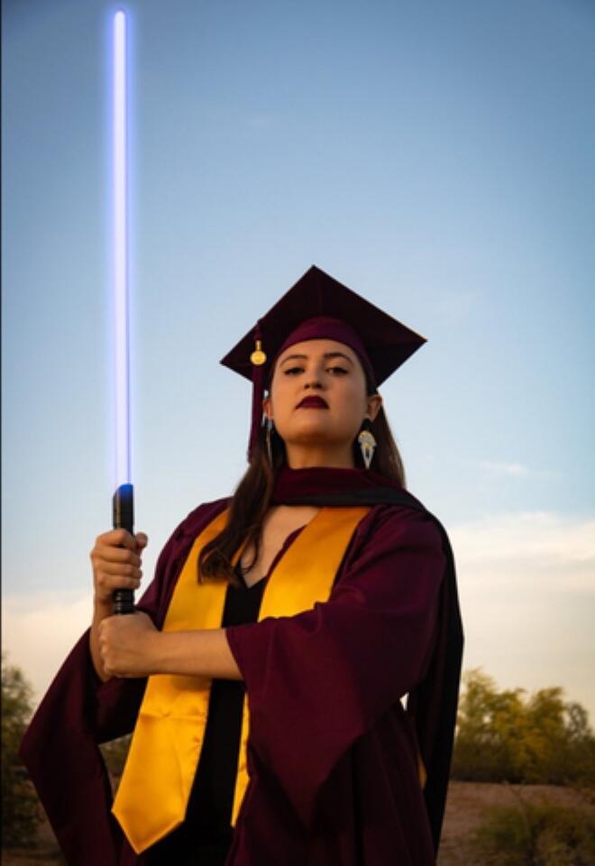 Sara Edwards celebrates with a lightsaber upon earning her master's degree in journalism from Arizona State University in April 2022. (Submitted photo)