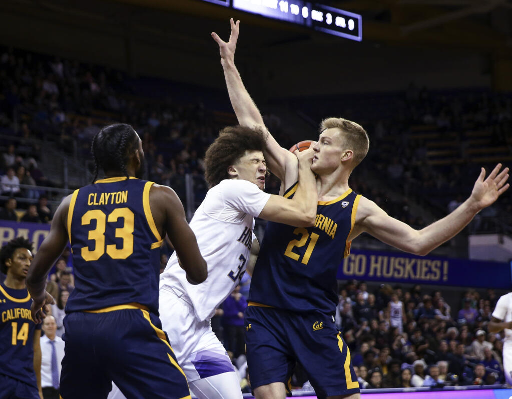 Washington center Braxton Meah collides with Cal forward Lars Thiemann during the second half Saturday in Seattle. (Lindsey Wasson / ASSOCIATED PRESS)