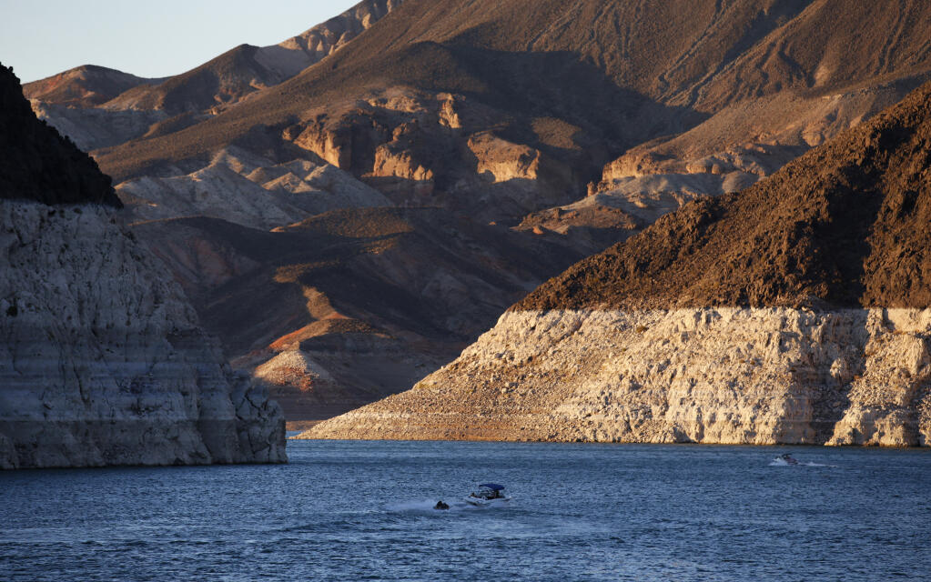 FILE - In this July 20, 2014 file photo, a bathtub ring of light minerals shows the high water line near Hoover Dam on Lake Mead at the Lake Mead National Recreation Area in Nevada. Six states in the U.S. West that rely on the Colorado River to sustain cities and farms rebuked a plan to build an underground pipeline that would transport billions of gallons of water through the desert to southwest Utah. In a joint letter Tuesday, Sept. 8, 2020, water officials from Arizona, California, Colorado, Nevada, New Mexico and Wyoming urged the U.S. government to halt the approval process for the project, which would bring water 140 miles (225 km) from Lake Powell in northern Arizona to the growing area surrounding St. George, Utah. (AP Photo/John Locher,File)