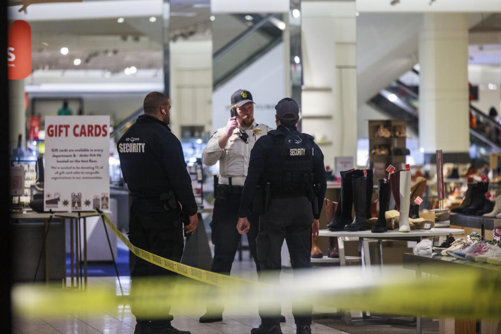 Security officers speak inside a store at the Mall of America in Bloomington, Minn., after reports of shots fired on Friday, Dec. 23, 2022. (Kerem Yücel/Minnesota Public Radio via AP)