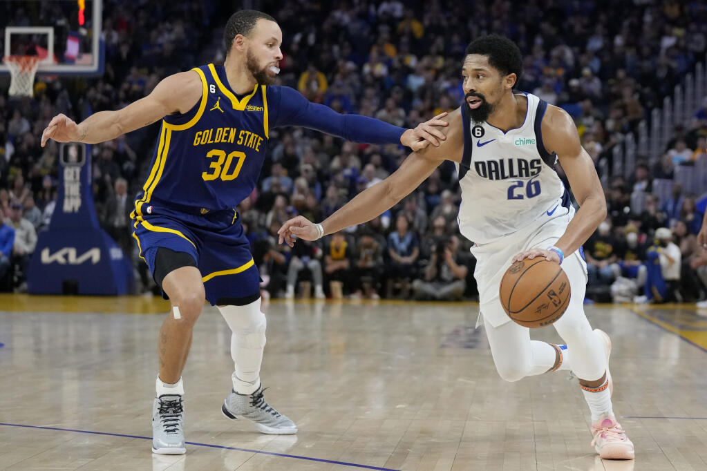 Dallas Mavericks guard Spencer Dinwiddie drives to the basket against Golden State Warriors guard Stephen Curry during the first half Saturday is San Francisco. (Jeff Chiu / ASSOCIATED PRESS)