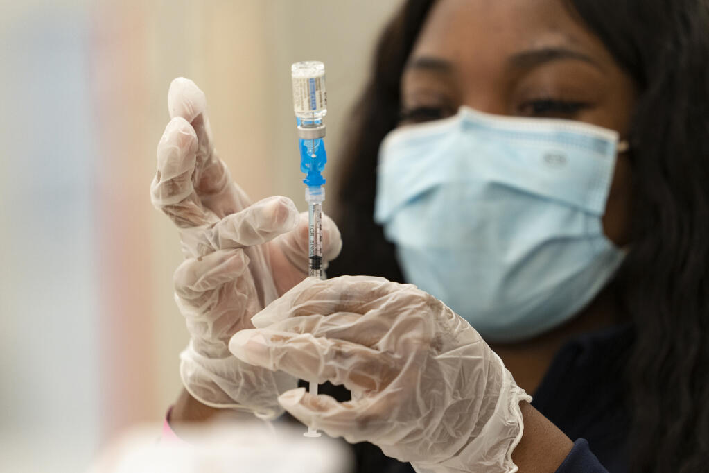 FILE - In this March 11, 2021, file photo, a health worker loads syringes with the vaccine on the first day of the Johnson & Johnson vaccine being made available to residents at the Baldwin Hills Crenshaw Plaza in Los Angeles. (AP Photo/Damian Dovarganes, File)