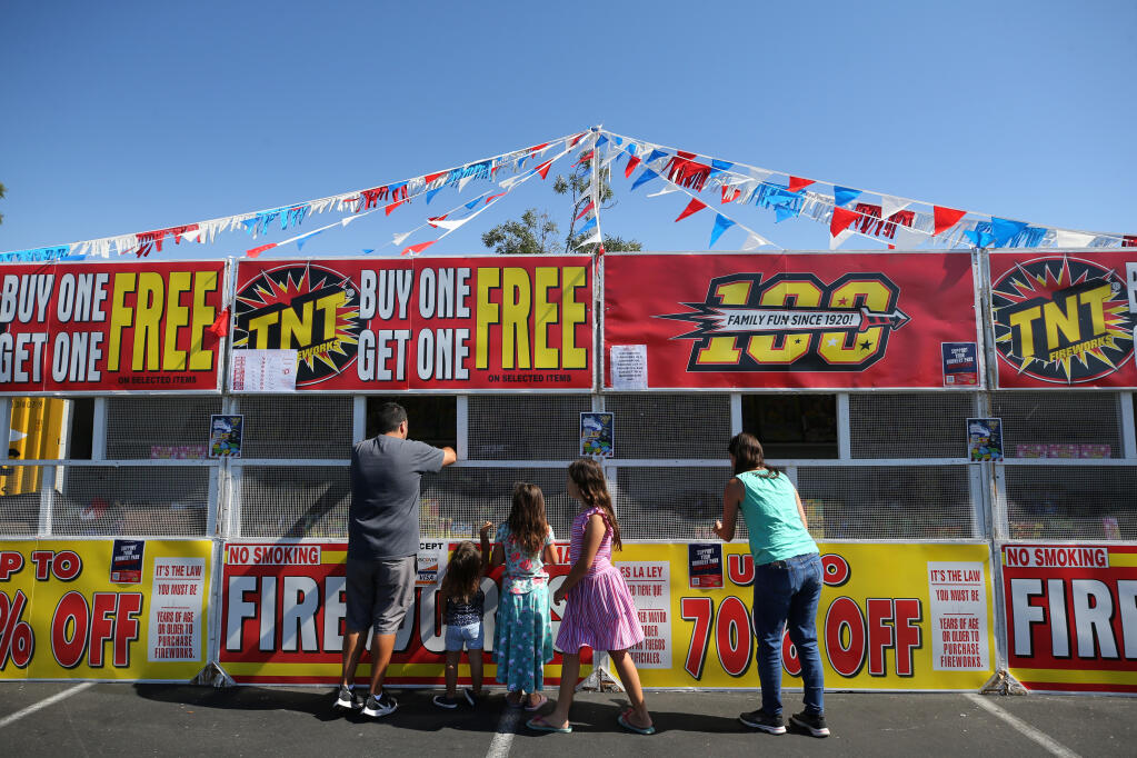 Members of the Moghtaderi family browse the firework selection for sale in the Home Depot parking lot in Rohnert Park, Calif., on Wednesday, June 30, 2021.(Beth Schlanker/The Press Democrat)