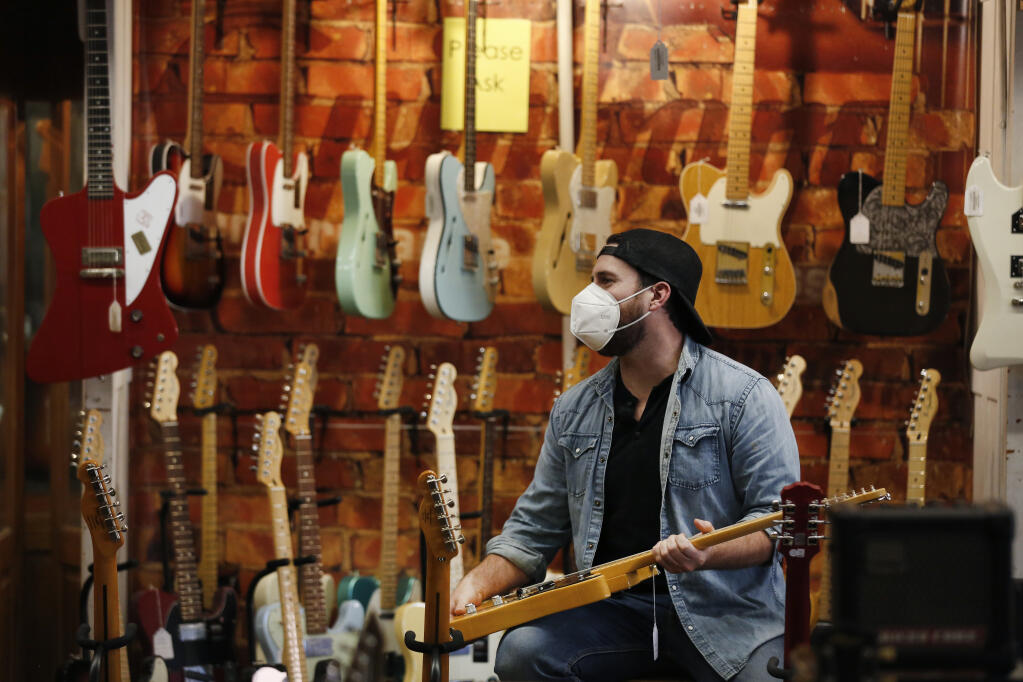 Musician Sean Carscadden tries out an electric guitar at Tall Toad Music in Petaluma on Thursday, Jan. 14, 2021. (Beth Schlanker / The Press Democrat)