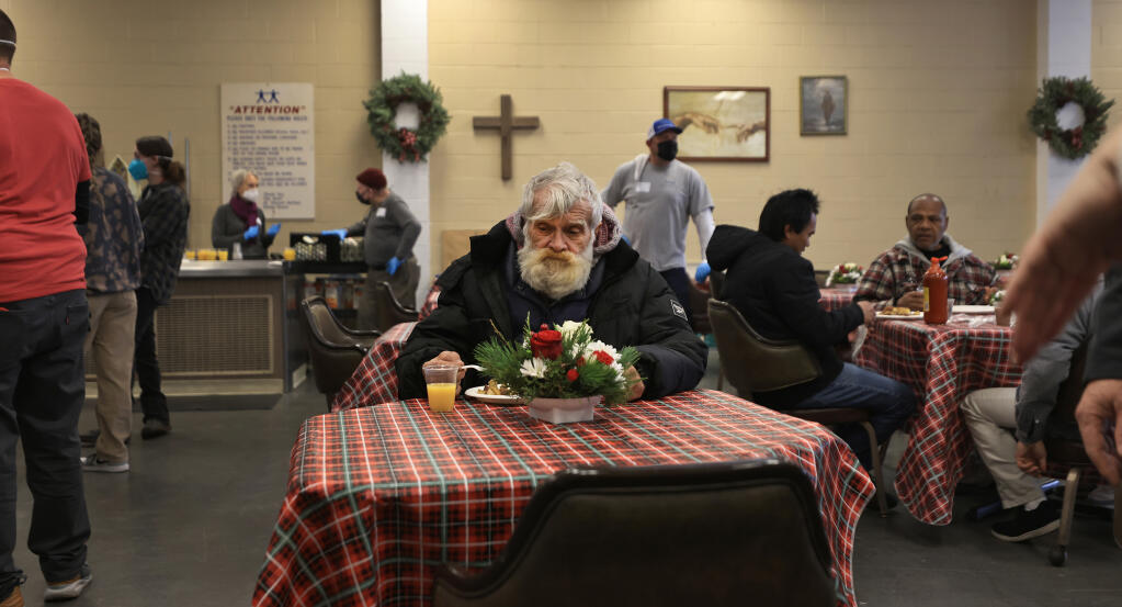 Joseph Jack sits down to a warm meal after a cold night, Friday, Dec. 23, 2022 at the St. Vincent de Paul Society dining room in Santa Rosa. The meal was part of a larger event, including foot messages, haircuts and cookie making, taking place at the Redwood Gospel Mission just down the street.  (Kent Porter / The Press Democrat) 2022
