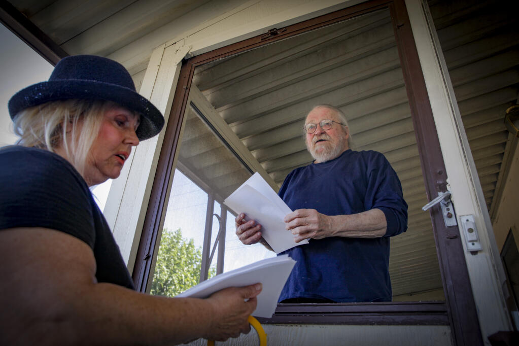 Jodi Johnson passes out information from the city of Petaluma for resources to assist residents of Youngstown Mobile Home Park. The 55-and-over park is home to many seniors on fixed incomes such as Patrick Hanks, a disabled military veteran who has lived in his mobile home for 40 years. Photographed Tuesday, August 8, 2023. (CRISSY PASCUAL/ARGUS-COURIER STAFF)