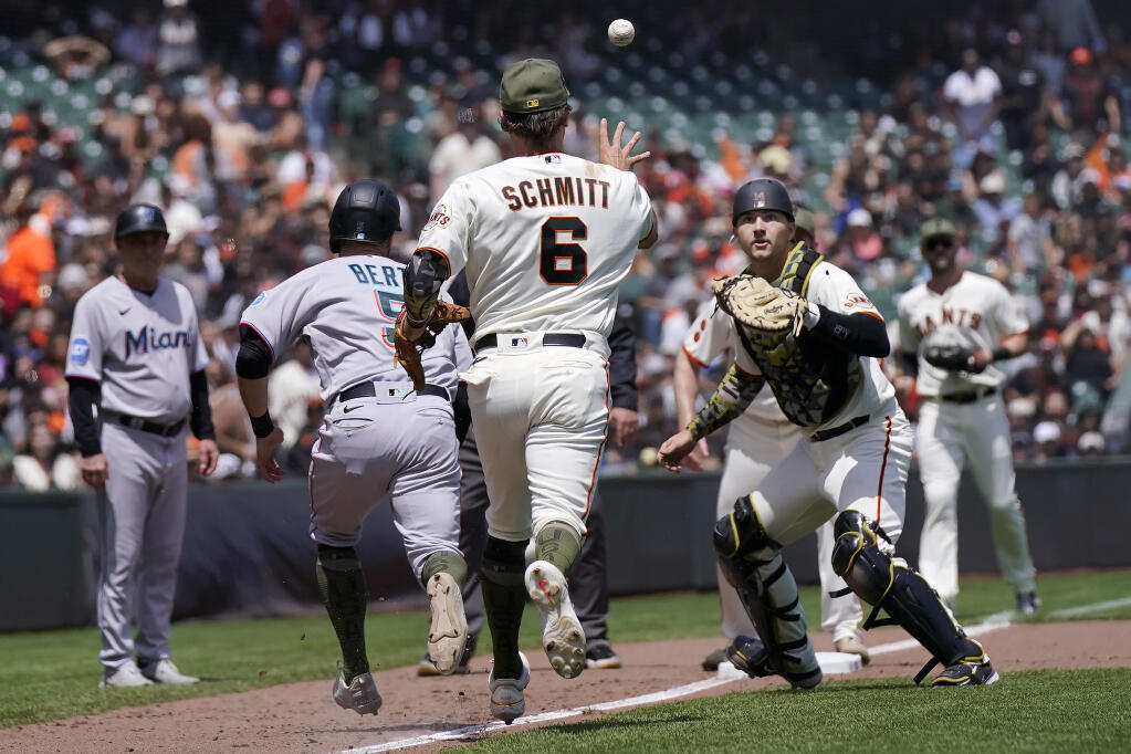 The Miami Marlins’ Jon Berti is caught in a rundown as Giants third baseman Casey Schmitt tosses the ball to catcher Patrick Bailey to tag Berti out during the fifth inning May 21 in San Francisco. (Jeff Chiu / ASSOCIATED PRESS)