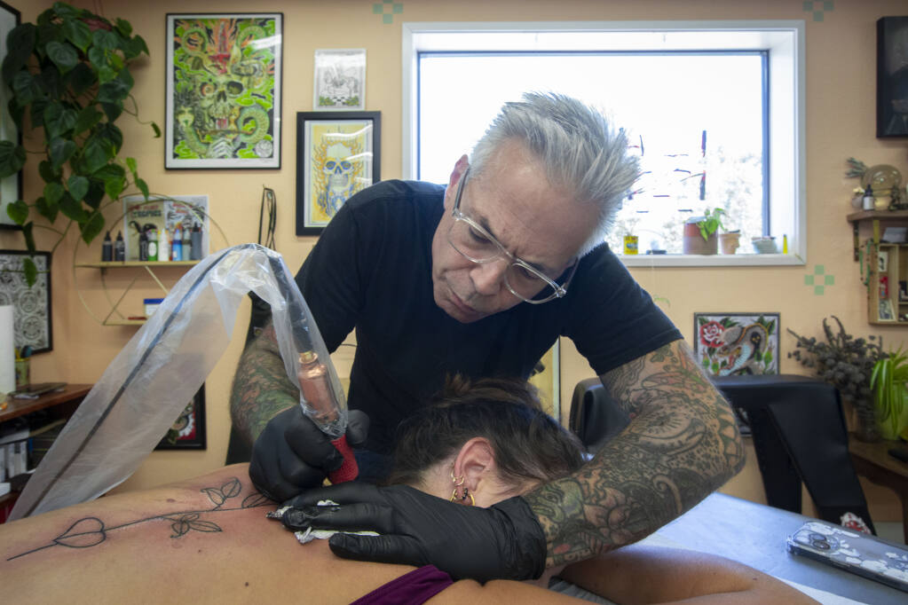 Jim Valavanis tattoos the outline of a rose and stem on Hannah Ladouceur at Rosa Grande Tattoo on Highway 12 in Sonoma on Monday, July 25, 2022. (Robbi Pengelly/Index-Tribune)