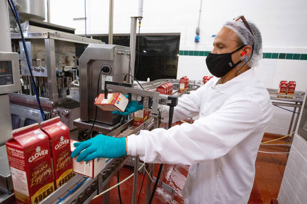 Bottling line worker Felix Sanchez conducts a quality control test on the packaging of Clover Sonoma premium organic eggnog, in Petaluma, California, on Thursday, December 10, 2020. (Alvin A.H. Jornada / The Press Democrat)