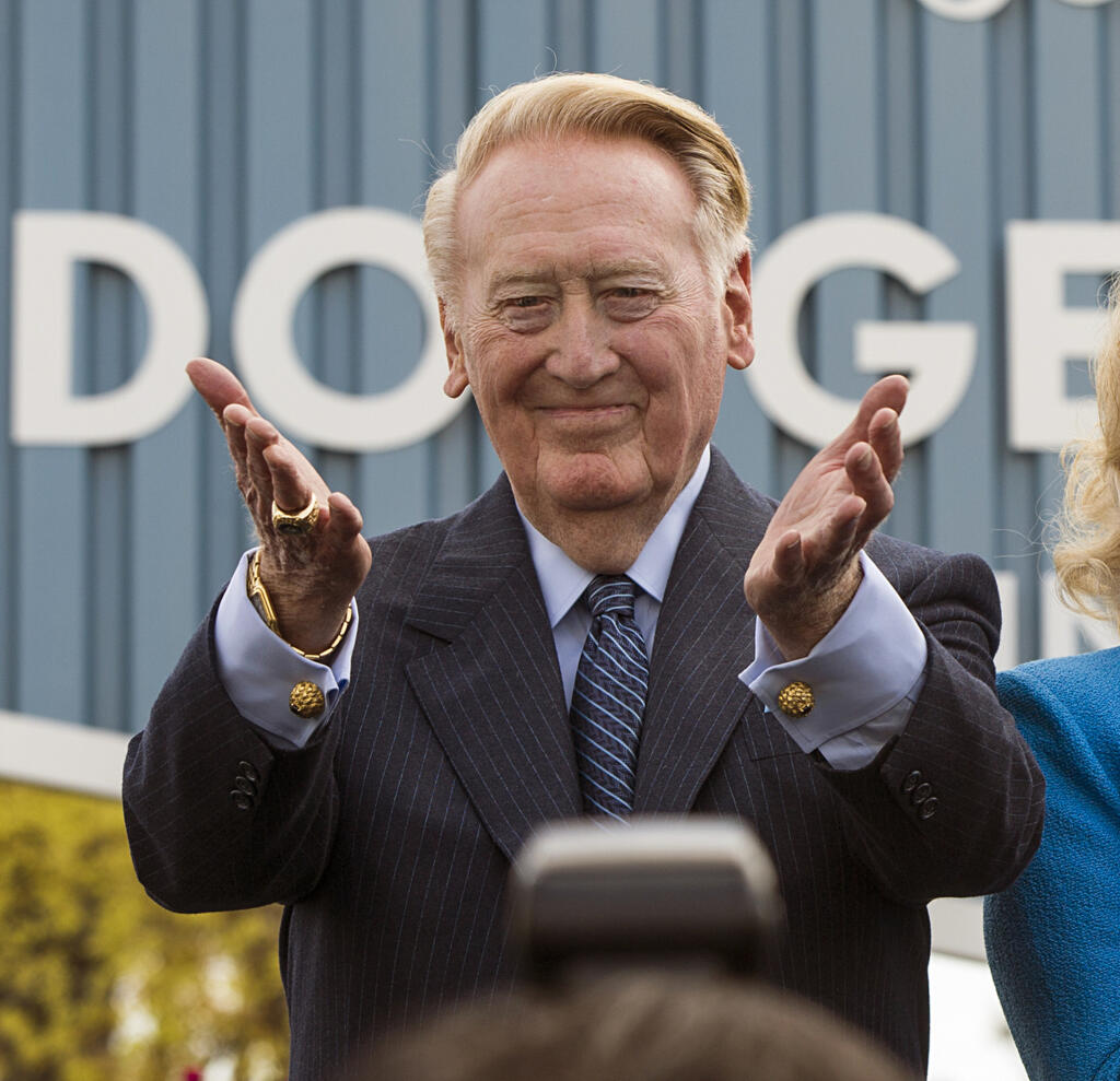 FILE - Los Angeles Dodgers broadcaster Vin Scully thanks fans at the unveiling of a street sign bearing his name at the entrance to Dodger Stadium, in Los Angeles on April 11, 2016. Scully, whose dulcet tones provided the soundtrack of summer while entertaining and informing Dodgers fans in Brooklyn and Los Angeles for 67 years, died Tuesday night, Aug. 2, 2022, the team said. He was 94. (AP Photo/Damian Dovarganes, File)
