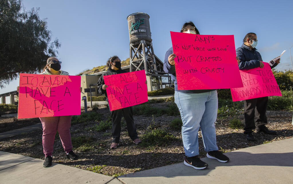Amy’s Kitchen production facility workers, from left, Lesbia Blanco, Inez De La Luz, Natalie Crisostomo and Adrian Guillen, protest the working conditions at the kitchen production facility outside the Amy’s Drive Thru in Rohnert Park on Jan. 26, 2022. (Chad Surmick / The Press Democrat)
