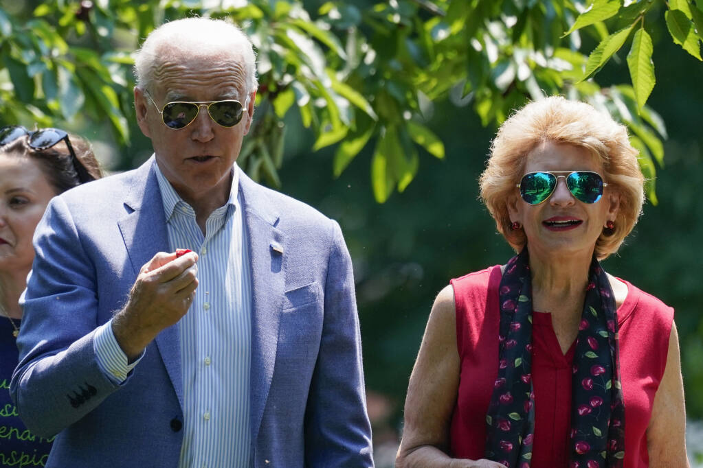 President Joe Biden eats a cherry as he tours King Orchards fruit farm Sen. Debbie Stabenow, D-Mich., Saturday, July 3, 2021, in Central Lake, Mich. (AP Photo/Alex Brandon)