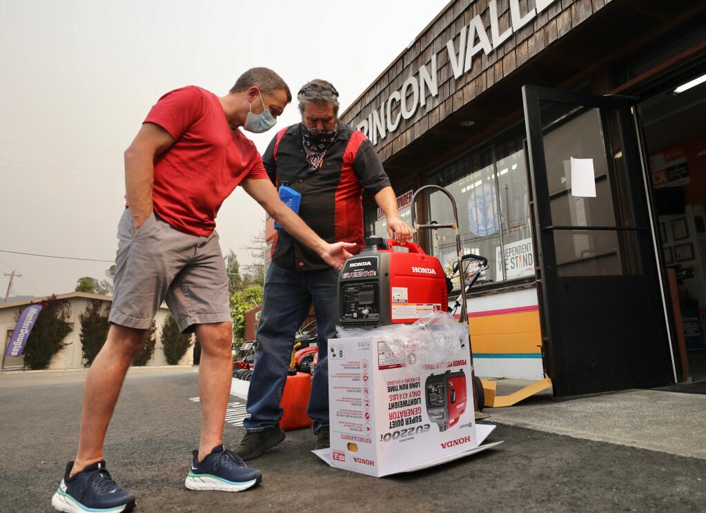Customer Justin Bowen, left, gets a lesson from Brett Nickelson, a service technician at Rincon Valley Yard and Garden, on how to care for a new generator that he purchased in Santa Rosa on Tuesday, Sept. 8, 2020. (Beth Schlanker / The Press Democrat)